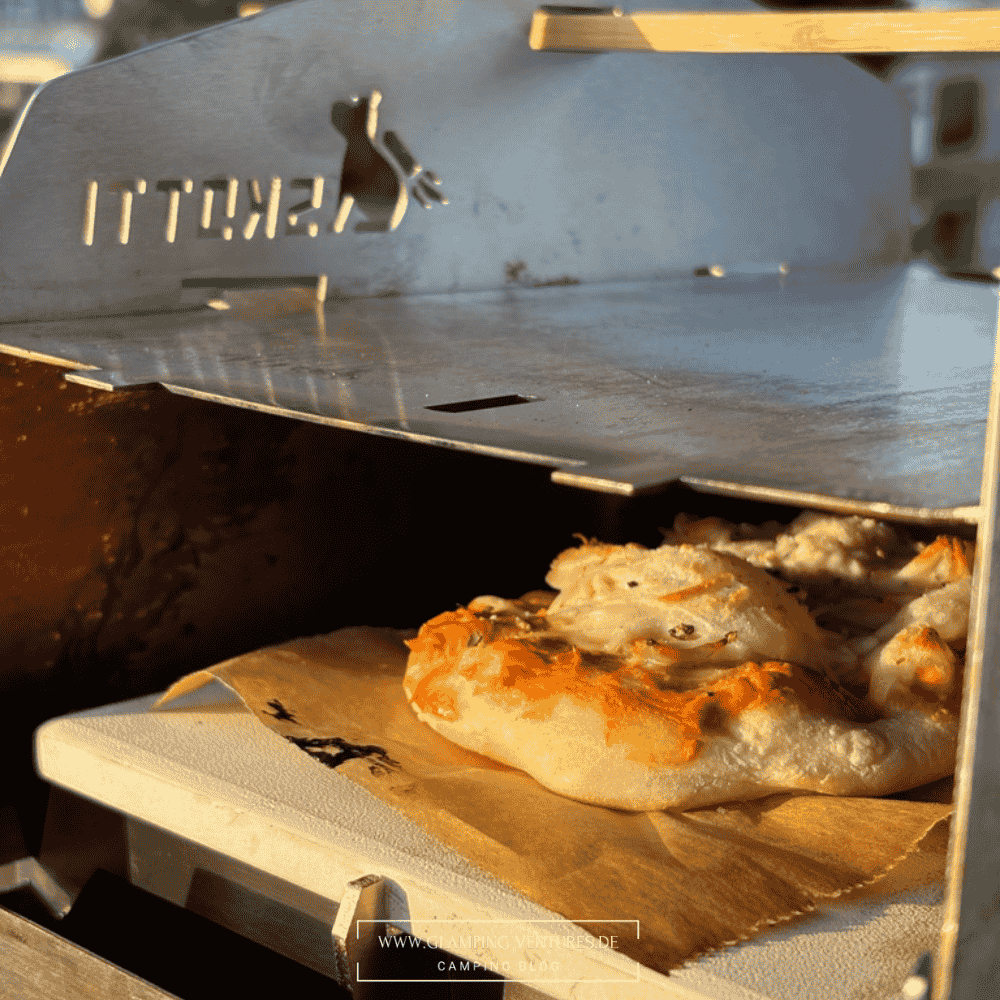 Mobiler Gasgrill mit Pizzastein für die Outdoor-Küche beim Camping