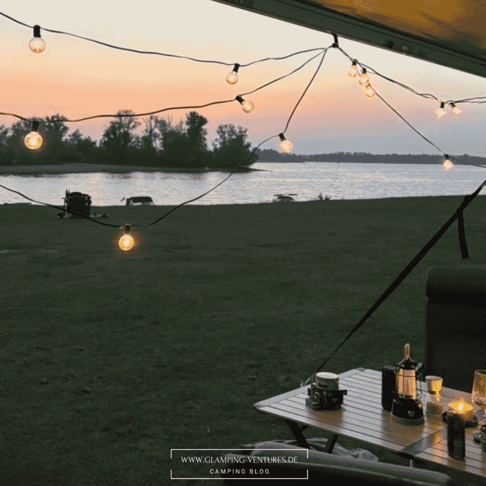 Stimmungsvoller Campingplatz mit Outdoor-Teppich und Lichterkette im Sommer