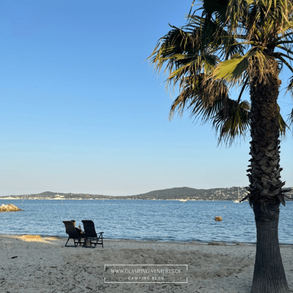 Camper sitzt mit deinem Frühstück im Campingstuhl am Strand